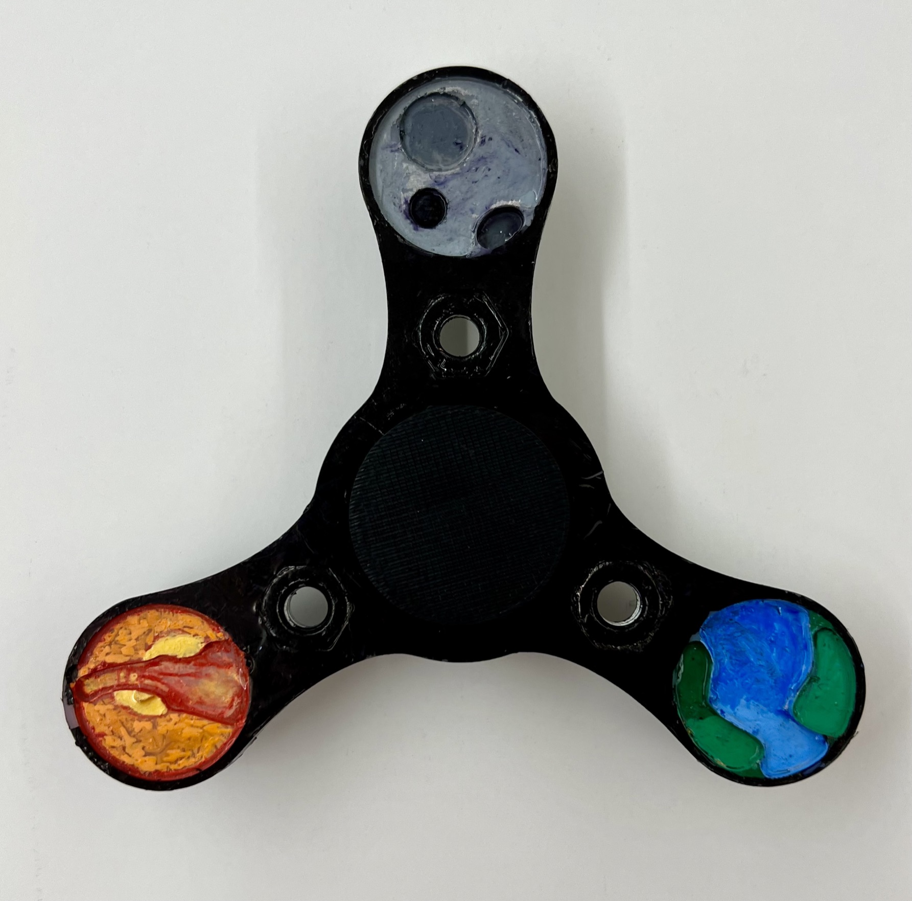 Finished black HDPE fidget spinner with hand-painted Earth, Moon, and Mars on the three arms